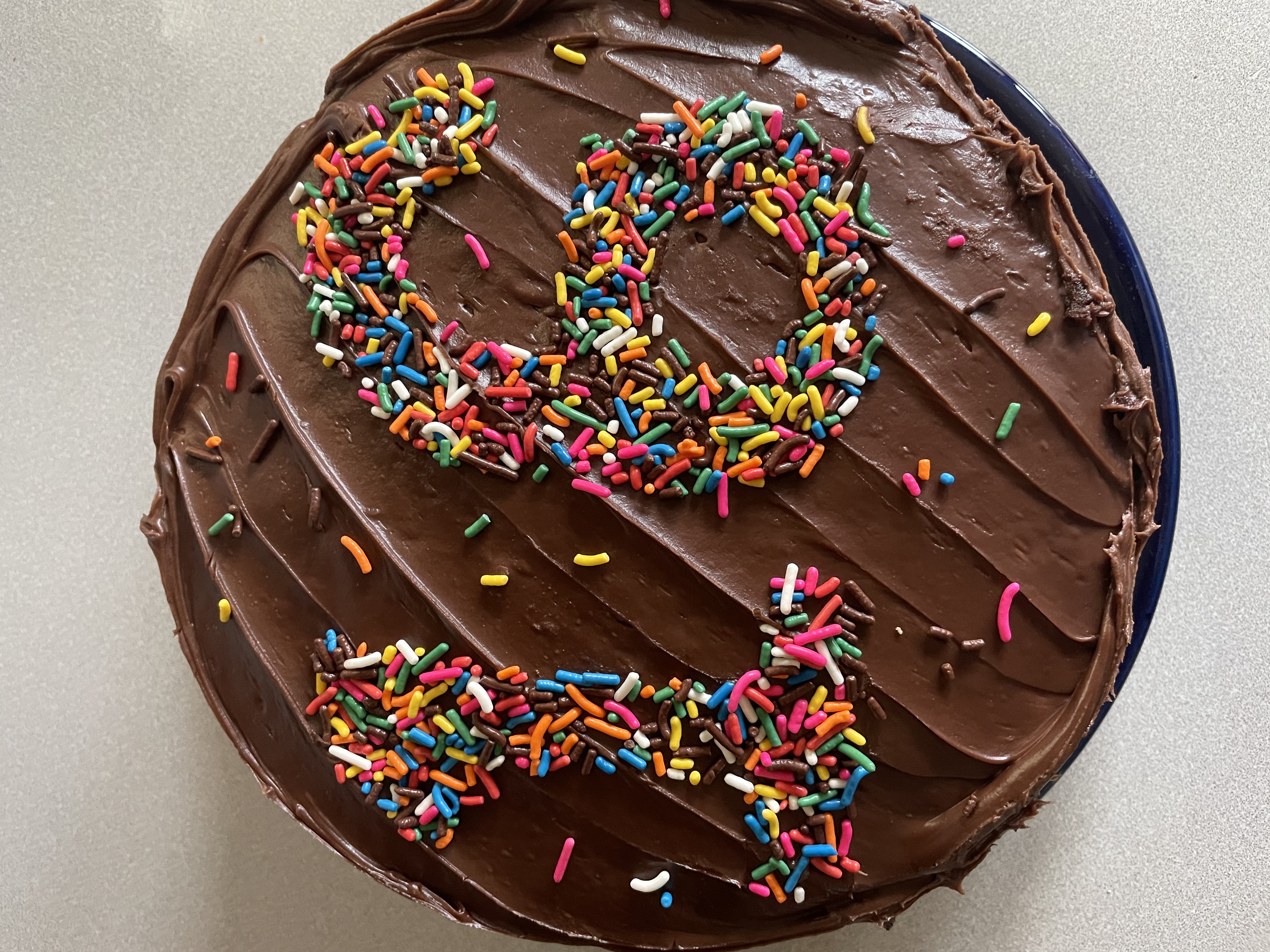 chocolate cake with sprinkles spelling out the number 16