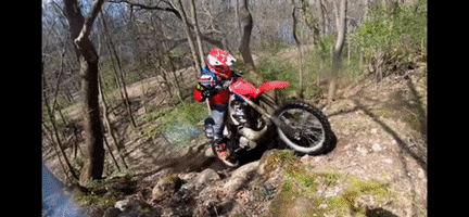 Moving Image of Daniel riding a dirtbike up steep hill and flipping it over at the top