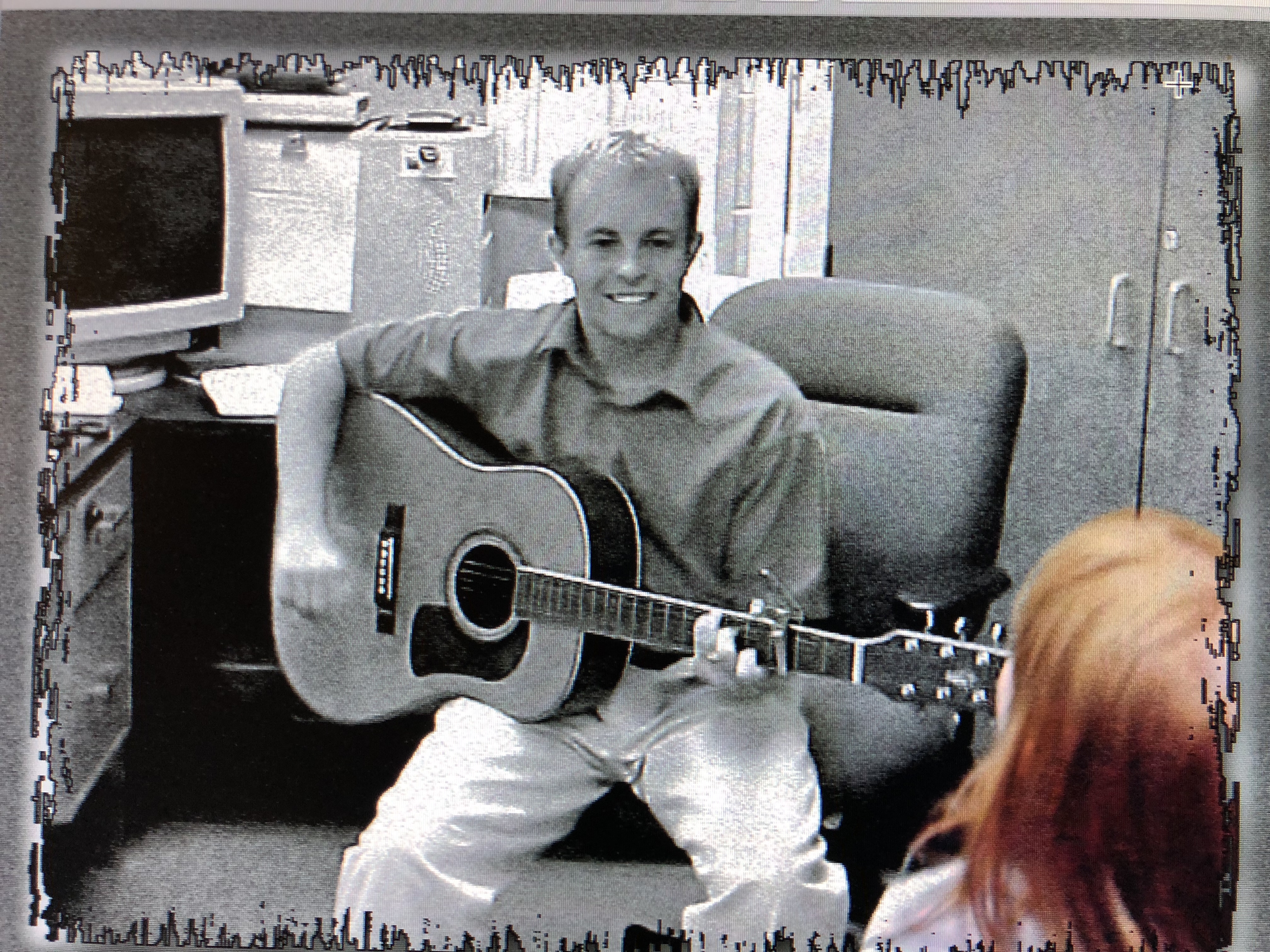 Daniel as a first year teacher playing guitar for students. 
