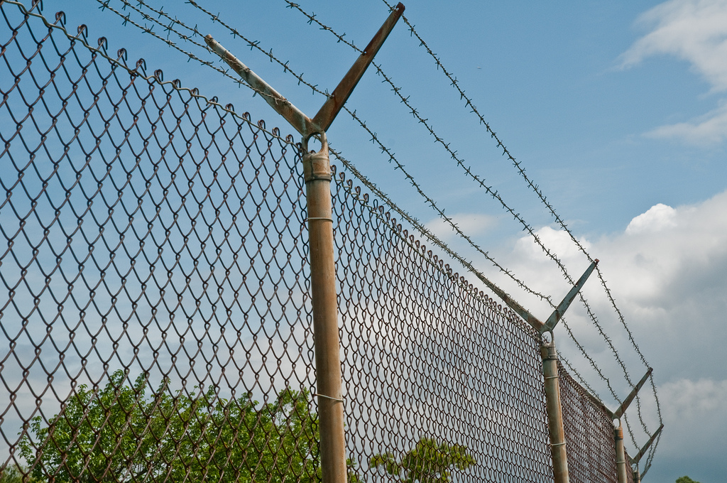 image of barrier, barbed-wire fence around a field
