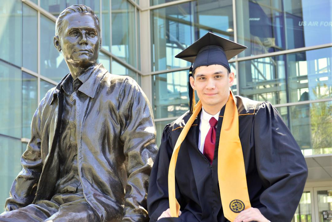 Derek sitting in Purdue University cap and gown